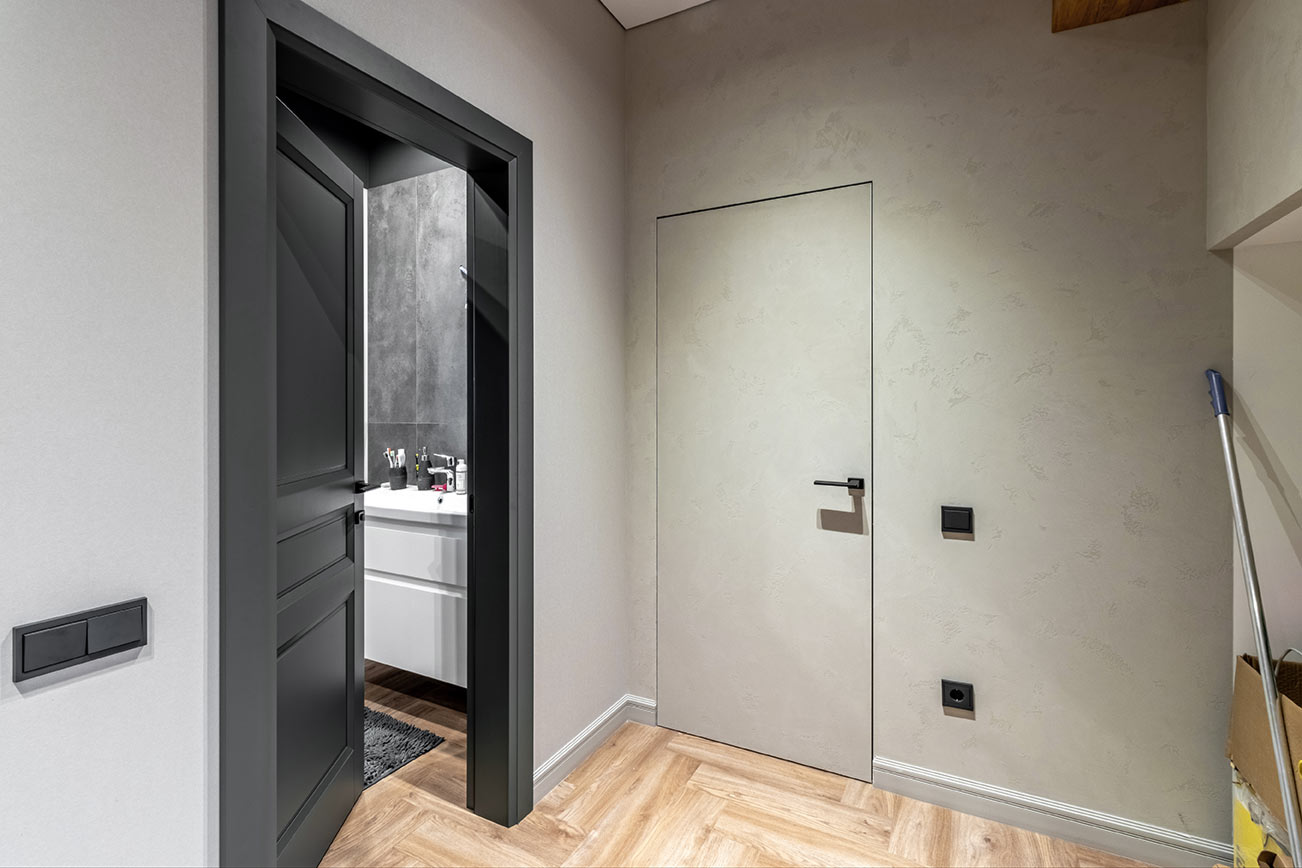 Dezente rahmenlose Zimmertür in Wandfarbe Grau – modernes Türdesign für stilvolle Innenräume Rahmenlose Innentür in grauer Wand mit minimalistischer Optik